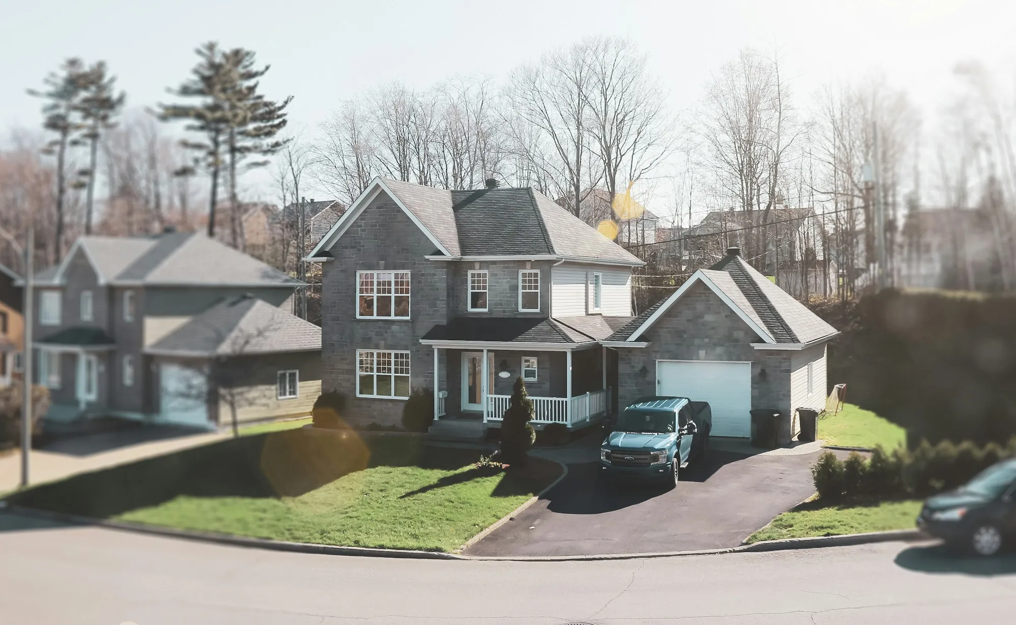 Suburban street with two-story homes and a car in the driveway