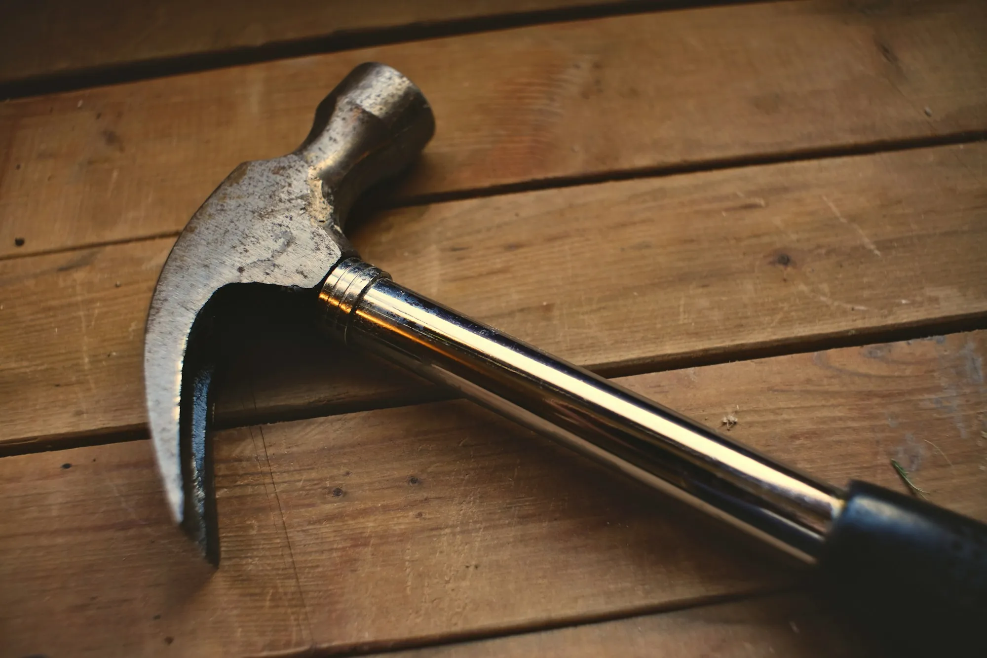 Steel claw hammer resting on wooden boards